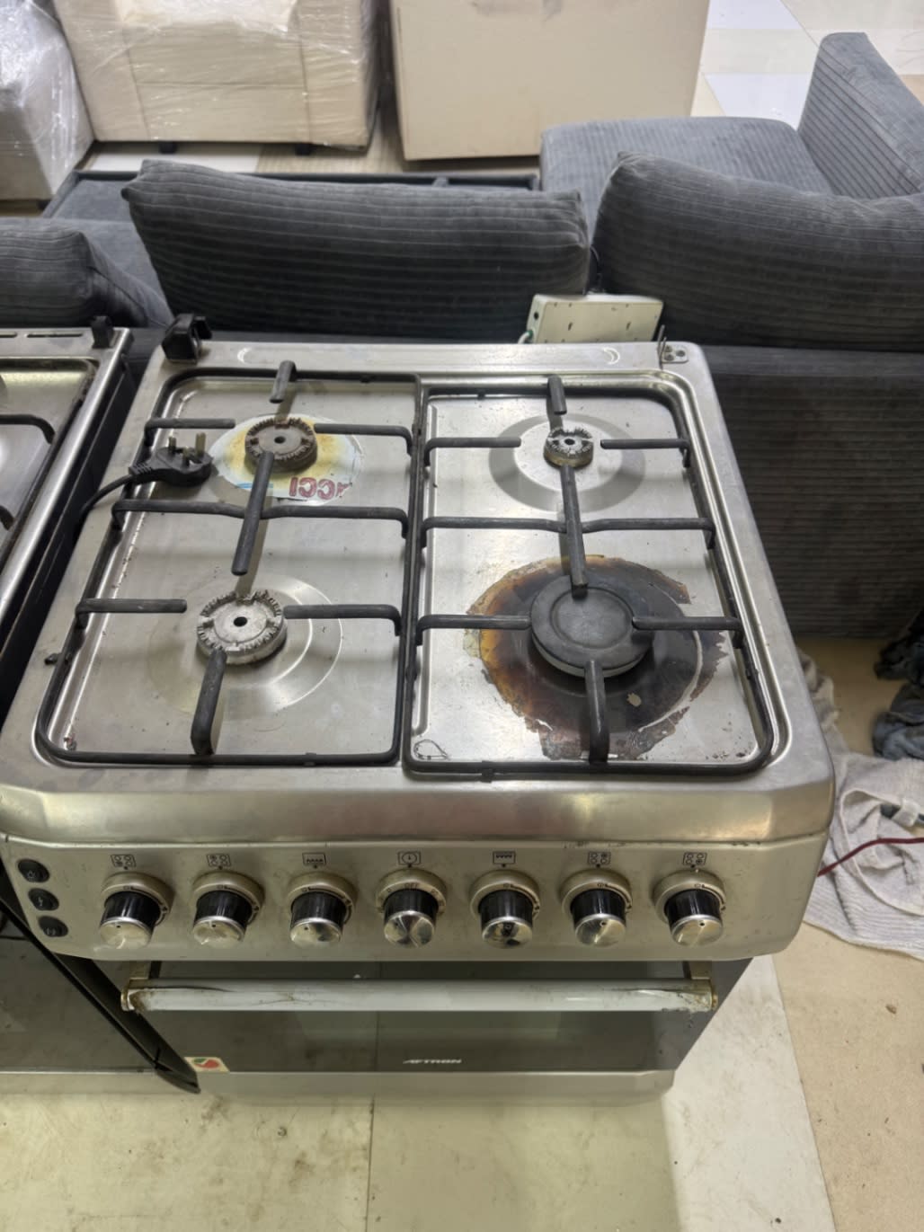 Top view of used Aftron gas cooker hob showing 4 burners with visible burn marks and surface wear