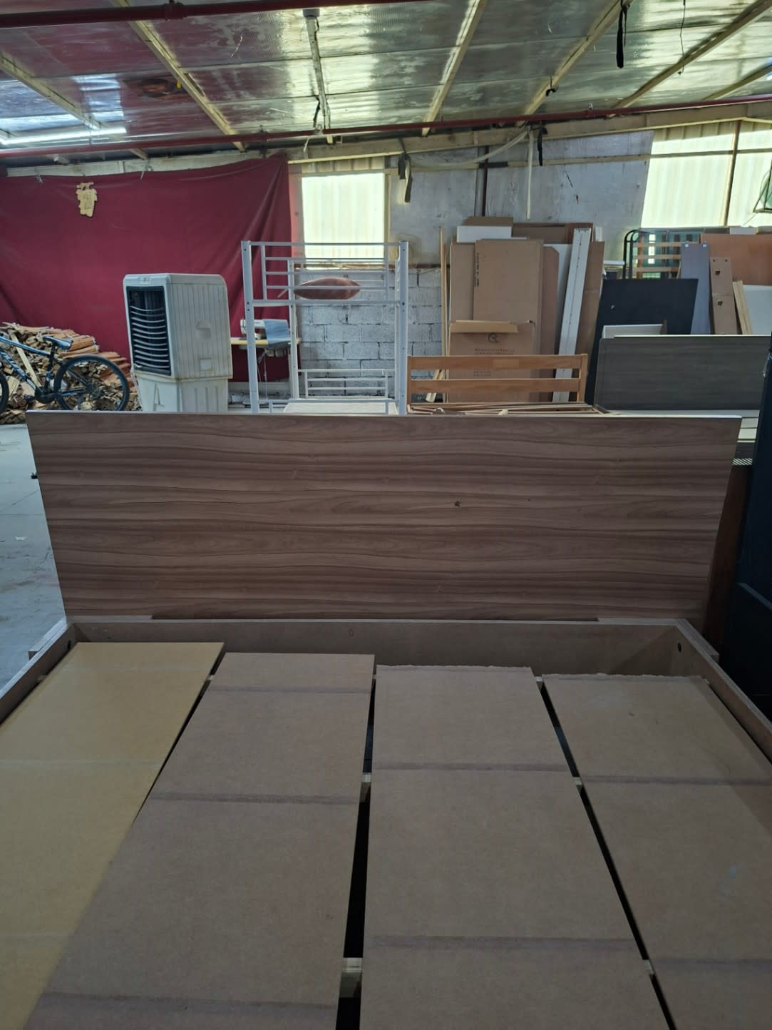 Rear view of used king bed frame headboard in walnut brown wood-grain laminate at Shop E Ajman