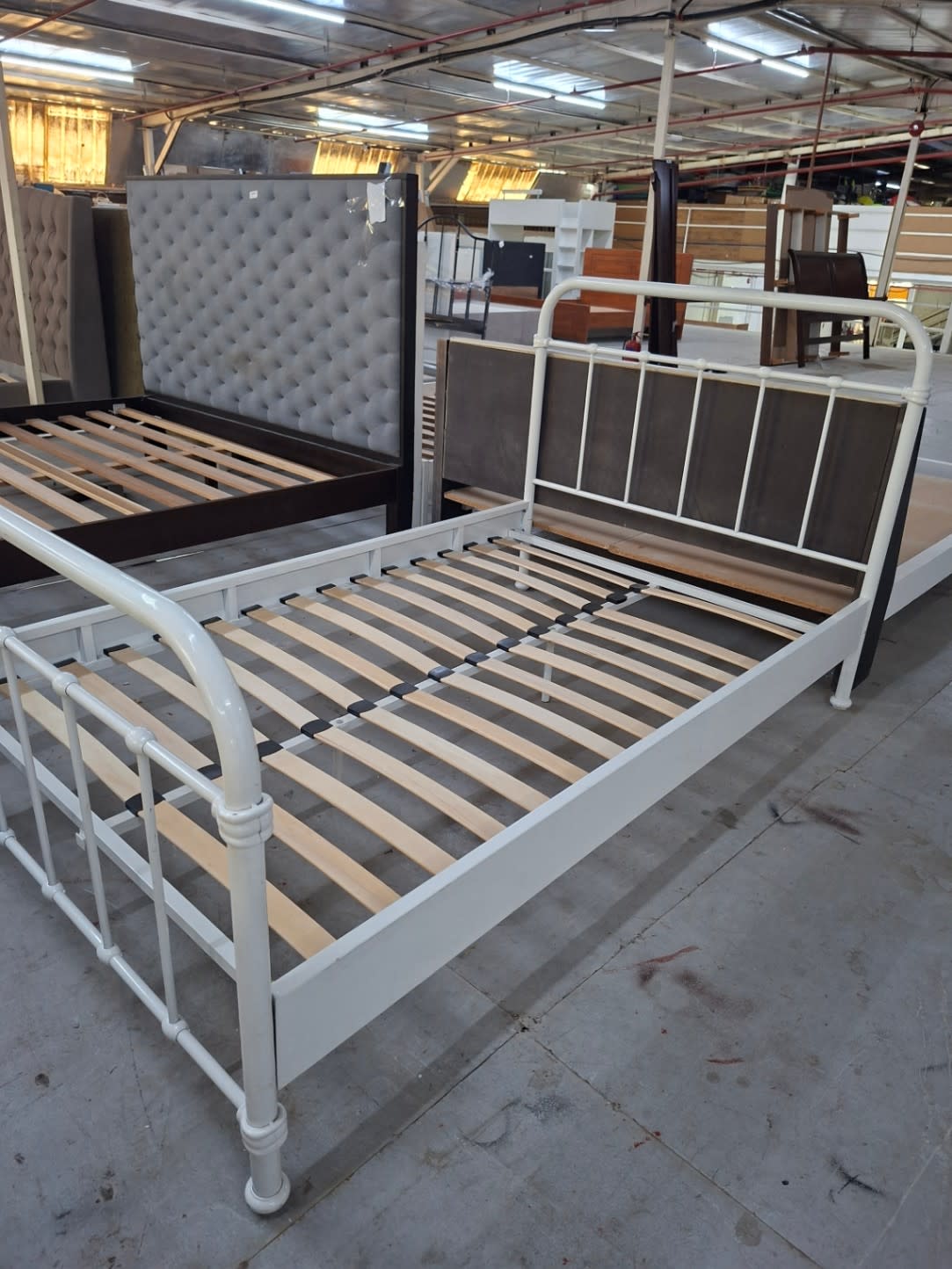 Wide angle view of used white metal bed frame at Bufaisal Shop E Ajman