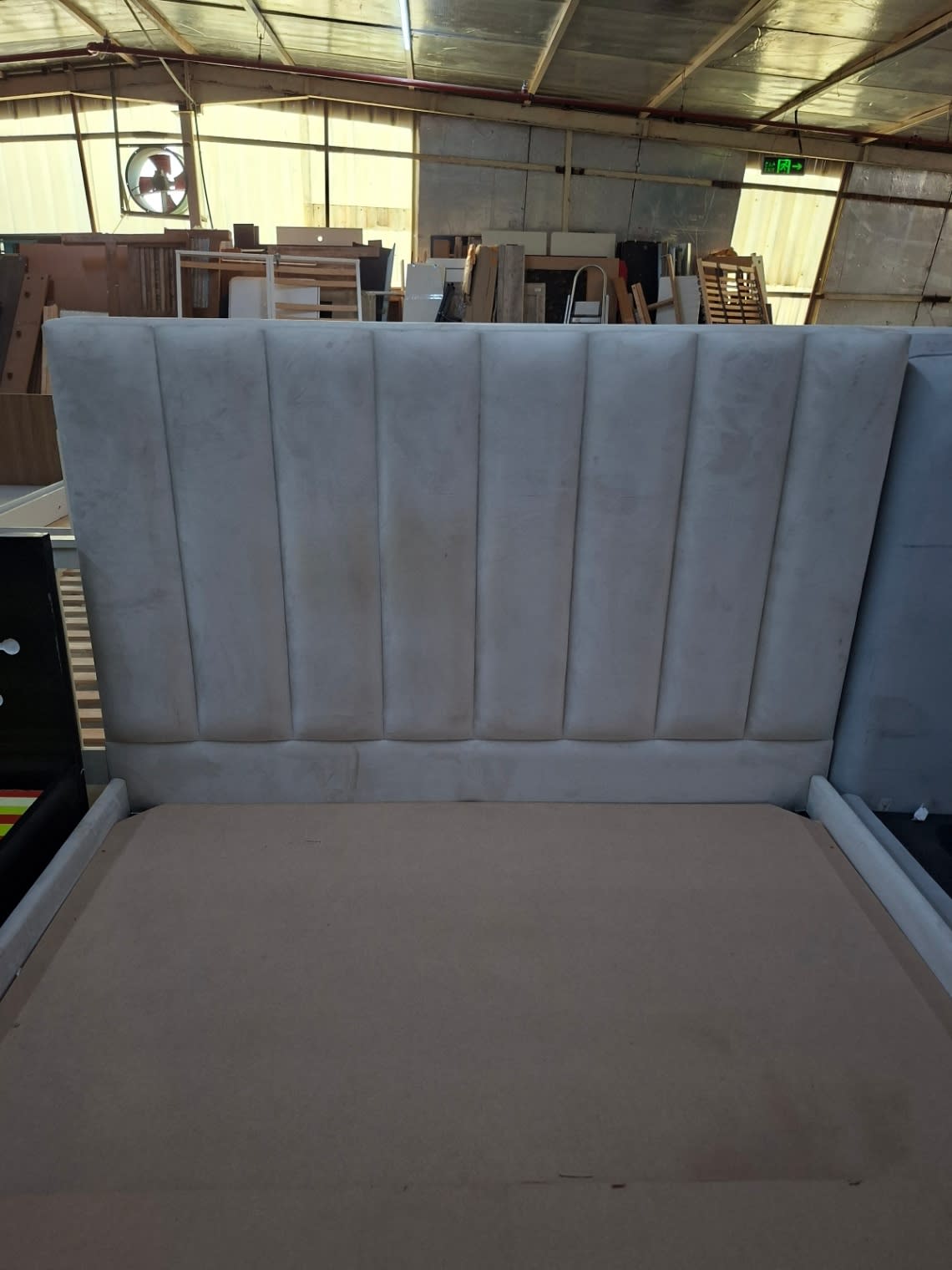 Close-up front view of tall channel-tufted headboard on used grey bed frame at Bufaisal Shop E Ajman