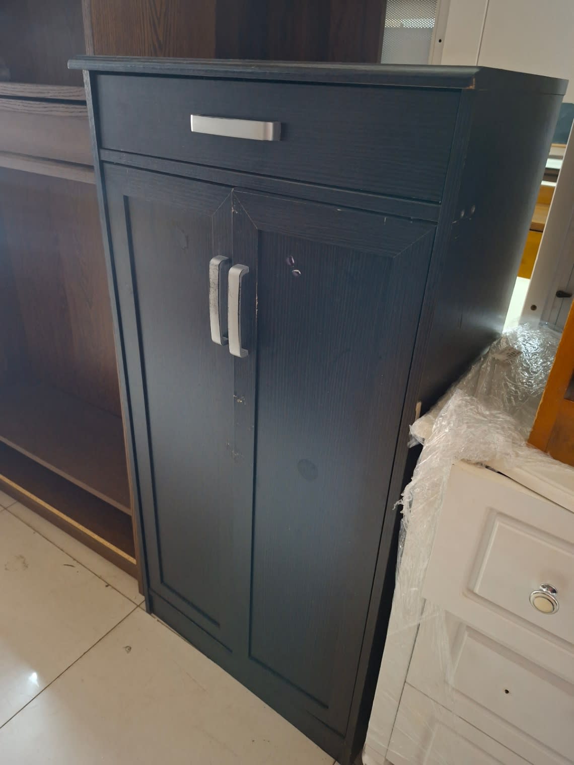 Side angle of used dark brown shoe cabinet showing door wear and overall structure