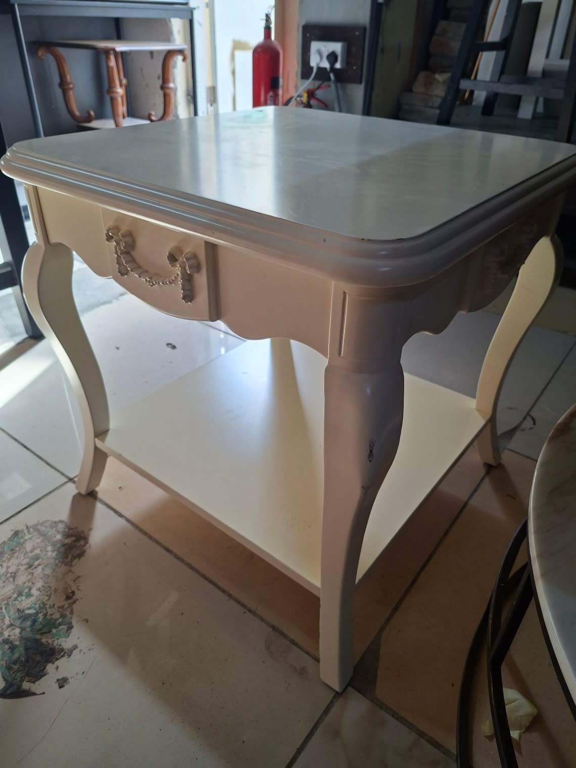 Alternate angle of used French-style white side table showing apron detail and paint condition at Bufaisal Ajman