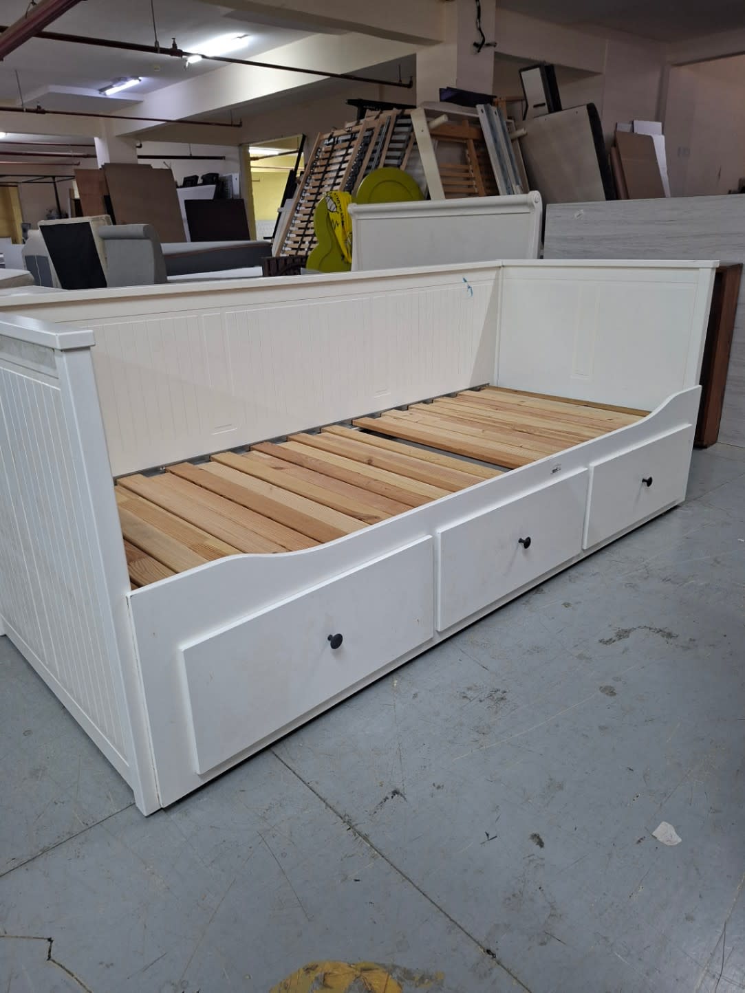 Front view of used white single day bed with beadboard paneling and three storage drawers at Bufaisal Ajman