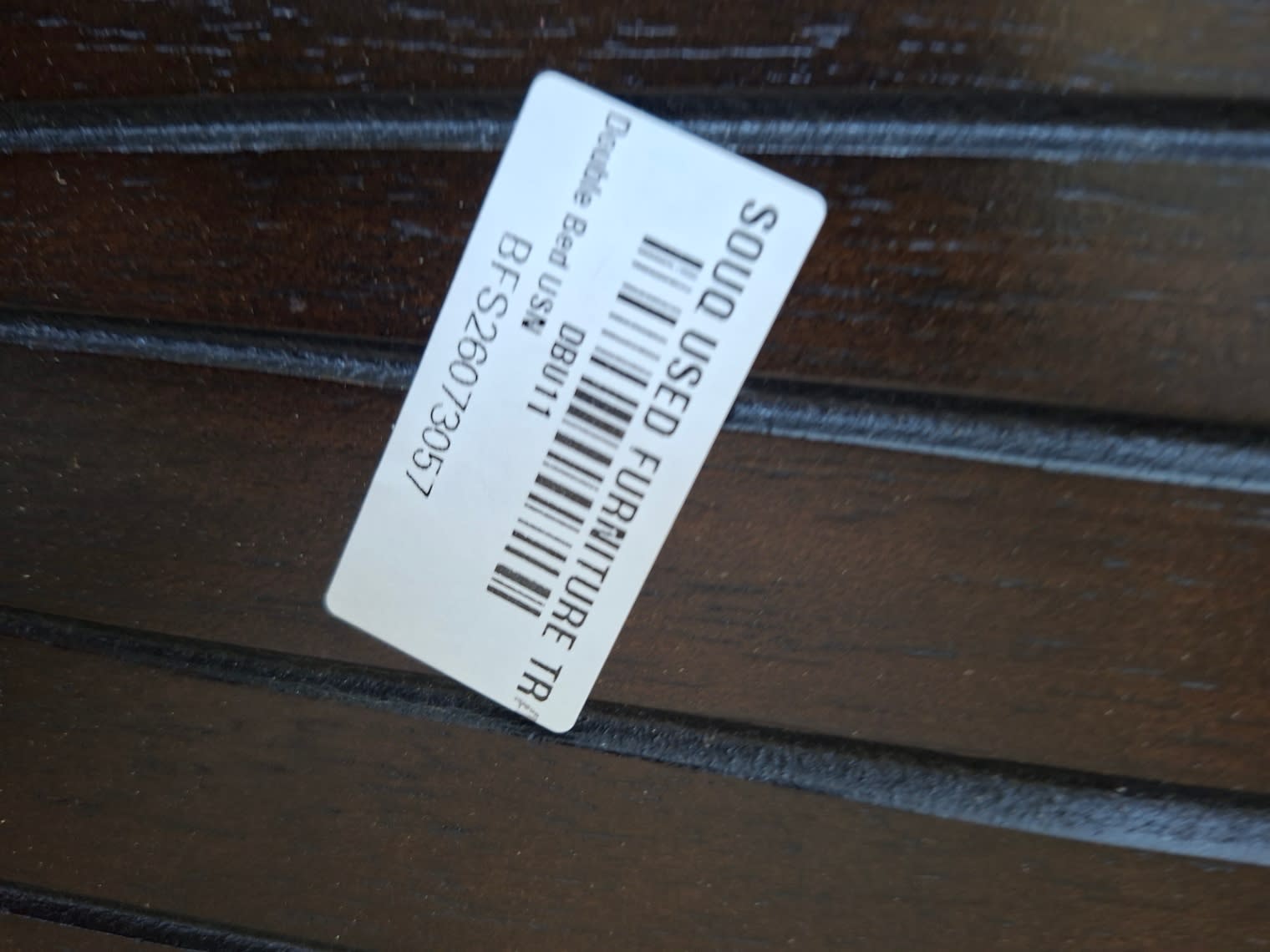Bufaisal barcode label BFS26073057 for used double bed frame at Shop C Ajman