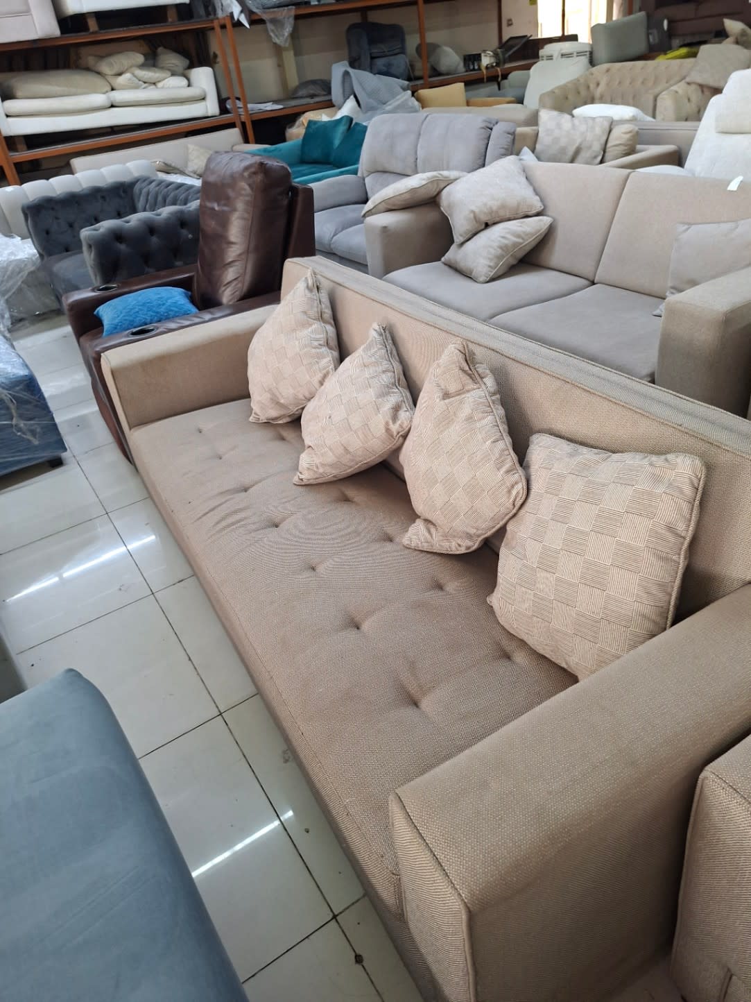 Close-up of used beige 3-seater sofa seat base showing surface wear and tufting at Bufaisal