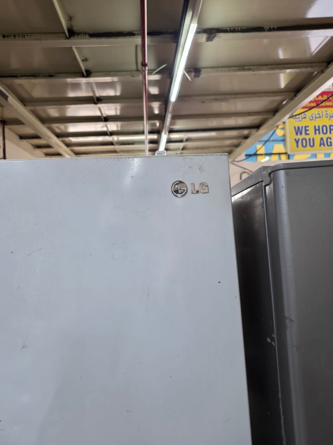 LG logo close-up on used white top-mount refrigerator at Bufaisal Ajman