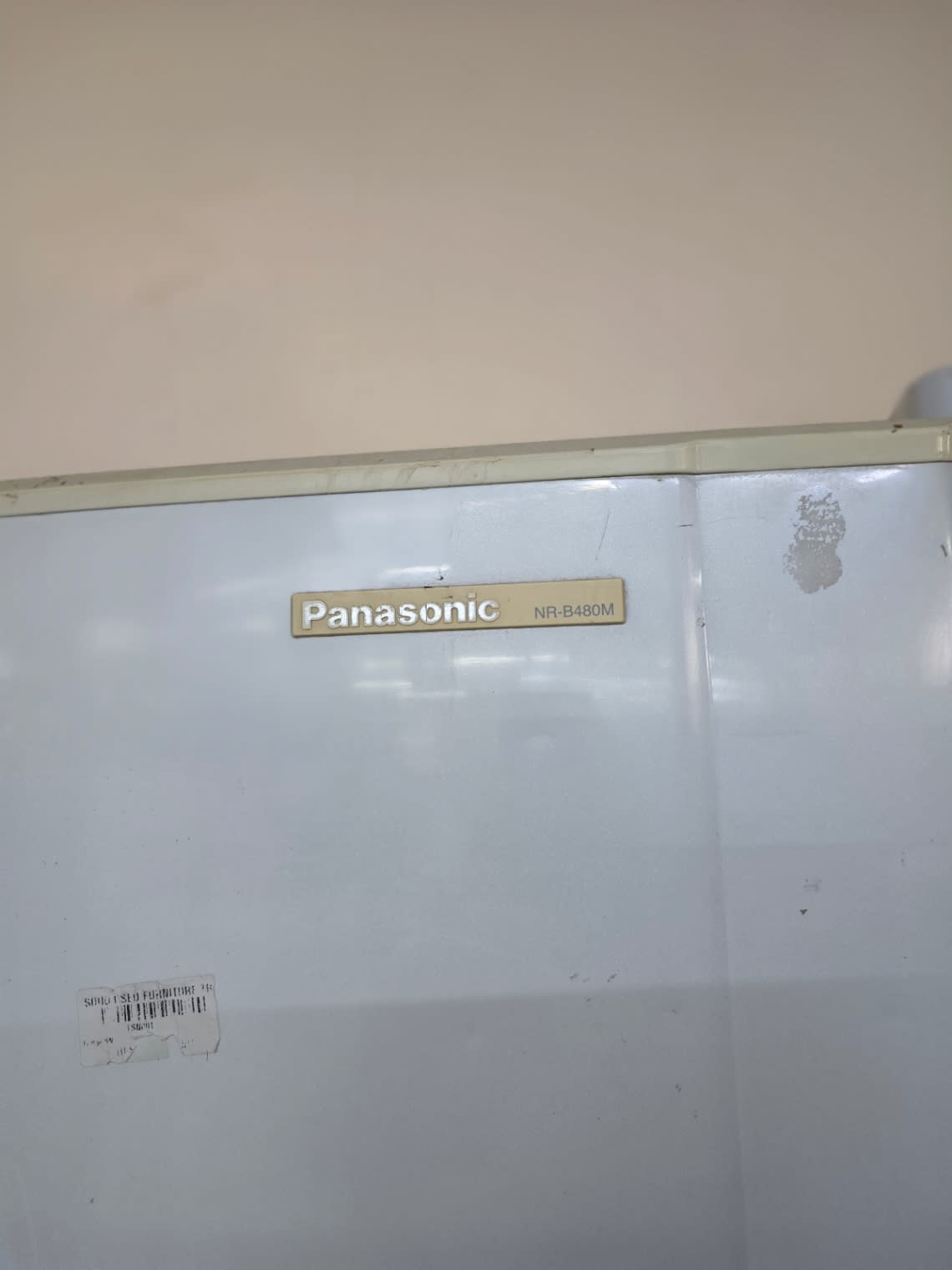 Bufaisal barcode label on used Panasonic NR-B480M top-mount refrigerator at Shop C Ajman