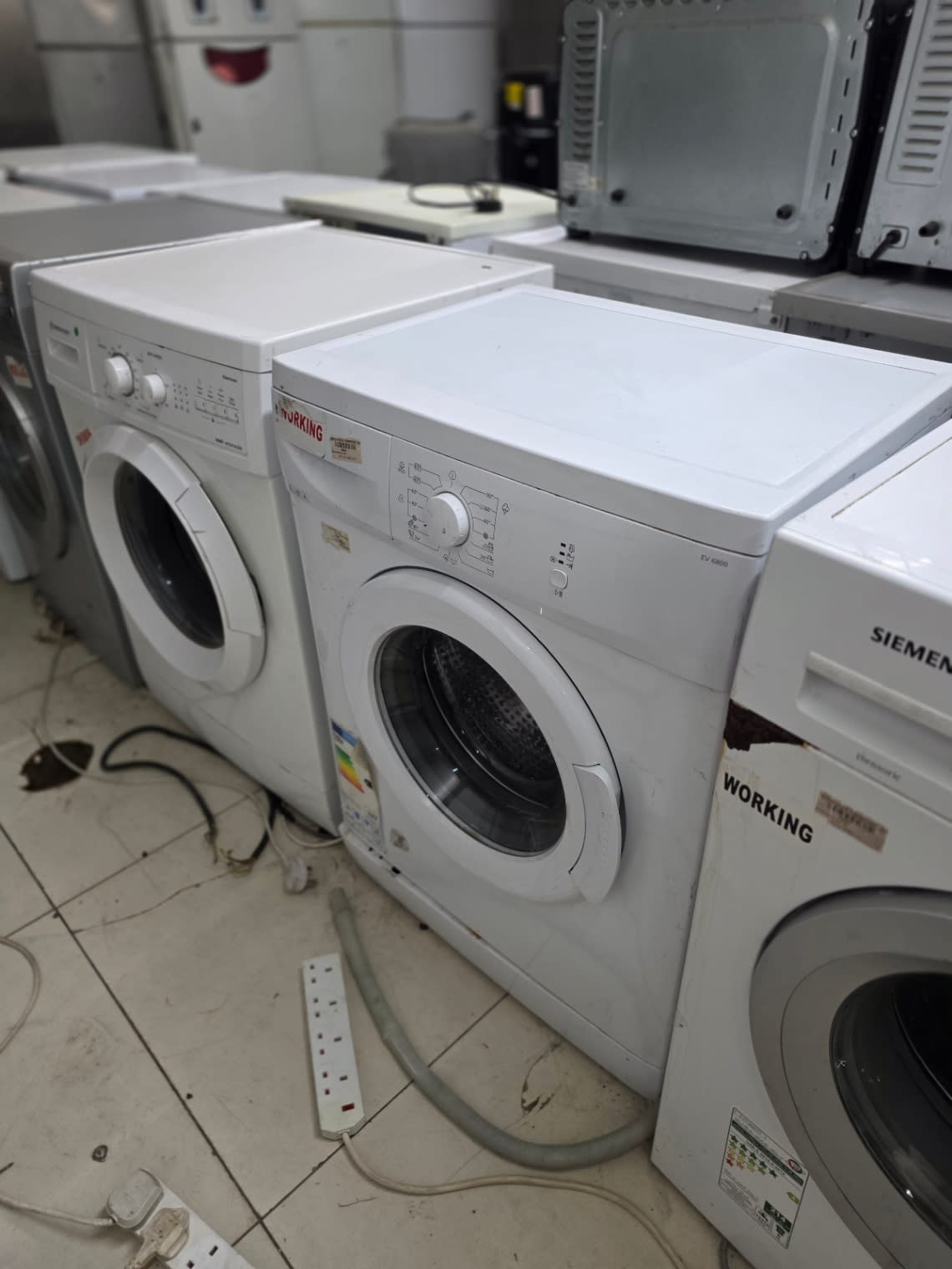 Bufaisal shop view showing used white front-load washing machine marked working at Shop C Ajman