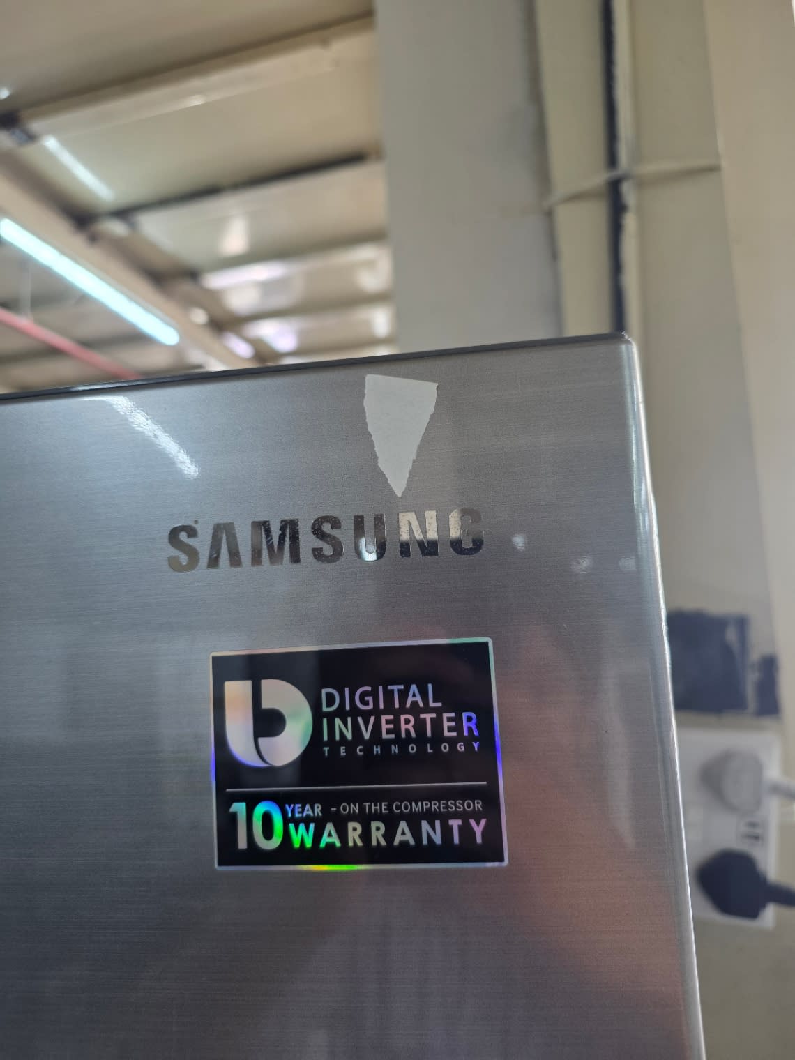 Samsung Digital Inverter Technology and 10-year compressor warranty sticker on used refrigerator at Bufaisal