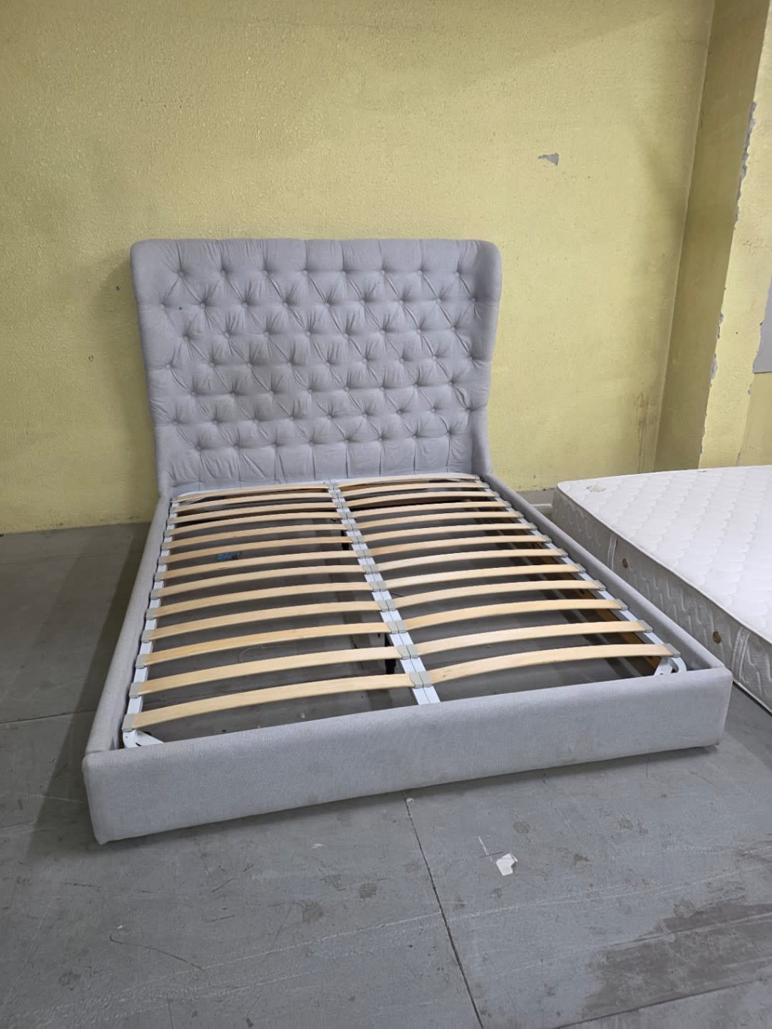 Bufaisal barcode label for used grey wingback tufted queen bed frame at Shop C Ajman