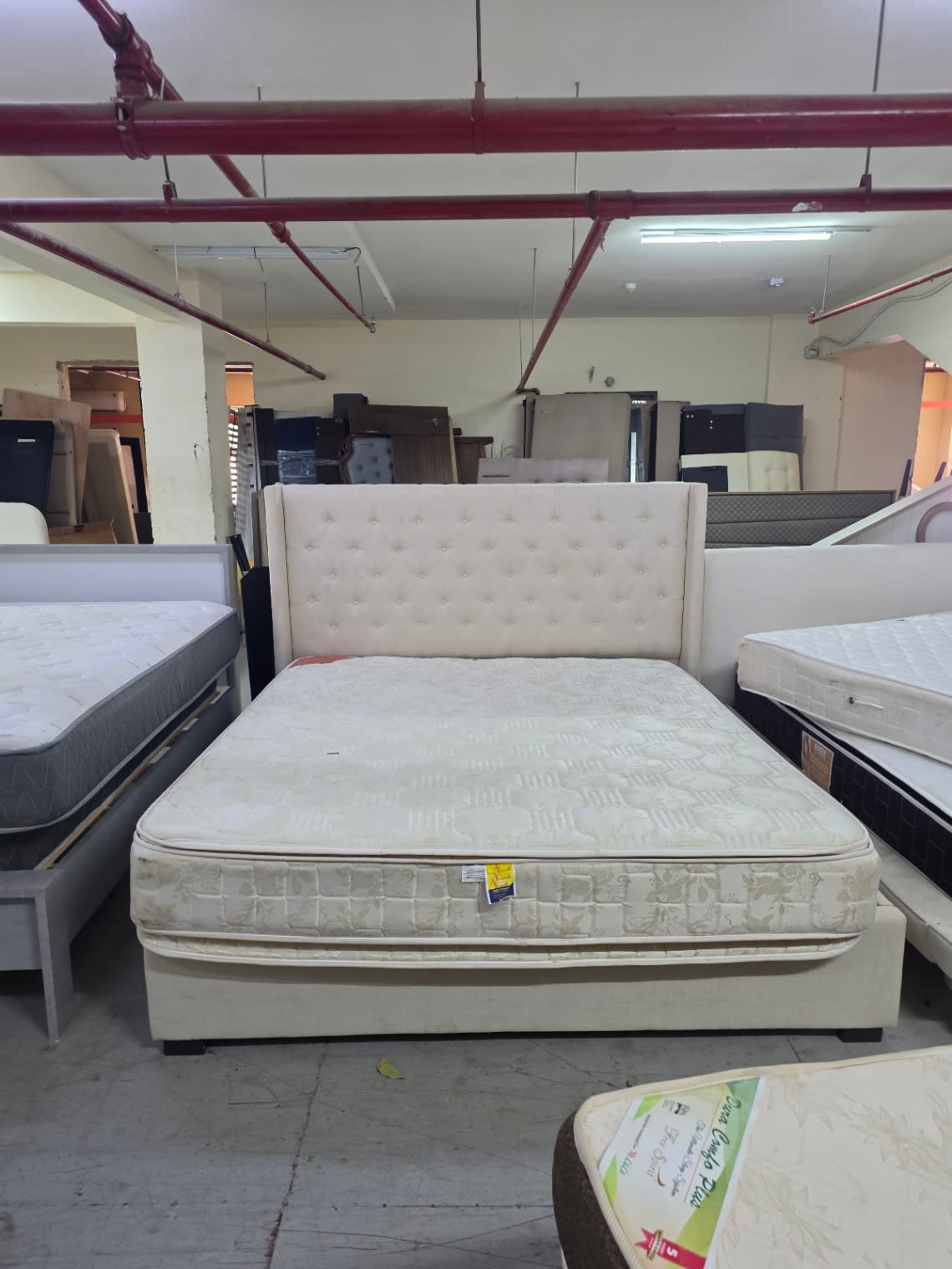Barcode label on used king bed frame with storage at Bufaisal Ajman