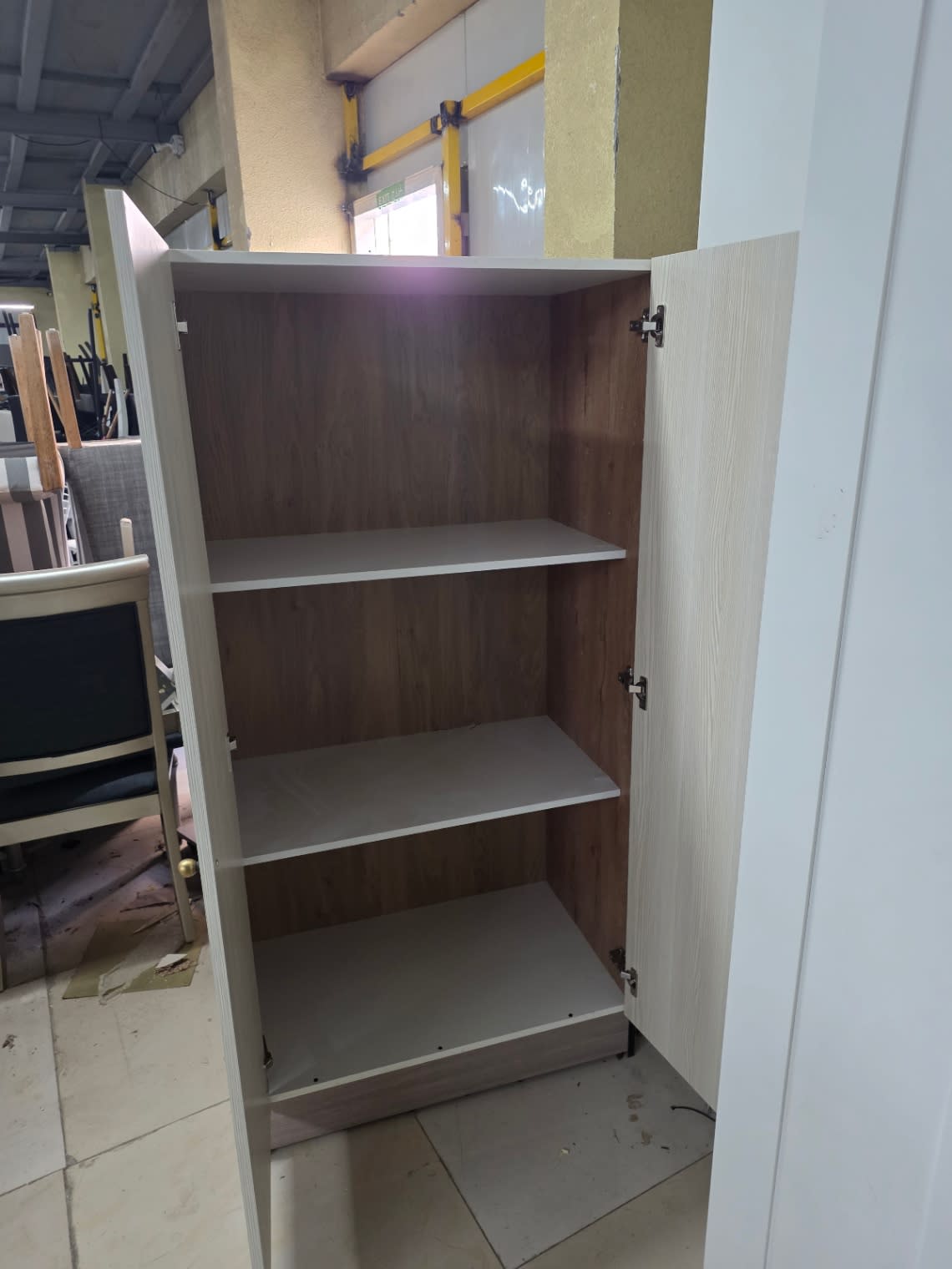 Interior detail of used storage cupboard showing shelves and hinges at Bufaisal Ajman