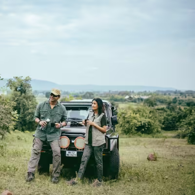 Guests enjoying a break near the lake with their safari jeep