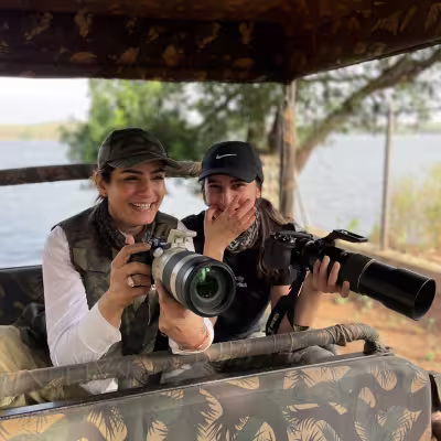 two ladies enjoying an exciting tiger sighting moment in the jeep. Irai lake in the background