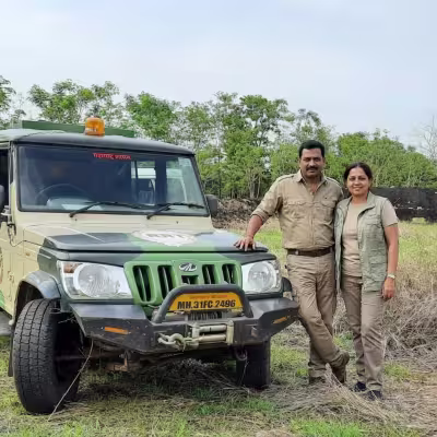 Guest posing with guide next to their vehicle in Moharli core zone