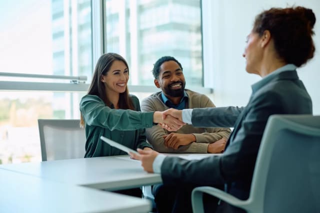 Two business professionals shaking hands after an LLQP enterprise partnership meeting