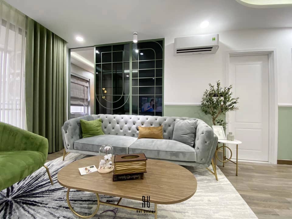 Phòng khách hiện đại căn hộ Sunrise Riverside với sofa cong và vách kính khung xanh