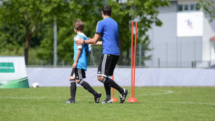 Der Trainer unterstütz seinen Spieler mit konkreten Hilfestellungen während des Trainings.