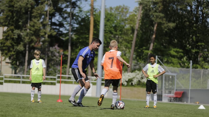 Der Trainer spielt bei einer Fussball-Übung selbst mit.