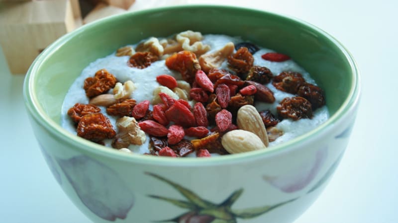 Auf dem Bild ist ein Mandeldrink mit verschiedenen Beeren zu sehen.