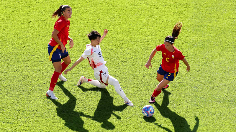 NANTES, FRANCE - JULY 25: Aitana Bonmati #6 of Team Spain runs with the ball under pressure from Aoba Fujino #15 of Team Japan during the Women's group C match between Spain and Japan during the Olympic Games Paris 2024 at Stade de la Beaujoire on July 25, 2024 in Nantes, France. (Photo by Robert Cianflone/Getty Images)