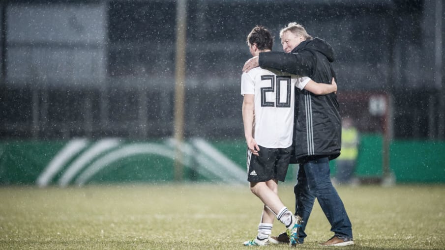 Hort Hrubesch zeigt nach einem U-19 Spiel Mitgefühl und Engagement © 2018 Getty Images Horst Hrubesch hat einen Arm um den U-19 Nationalspieler Yari Otto gelegt und spricht mit ihm nach einem Spiel. Es ist zu sehen, dass es stark regnet. (Photo by Lukas Schulze/Bongarts/Getty Images)