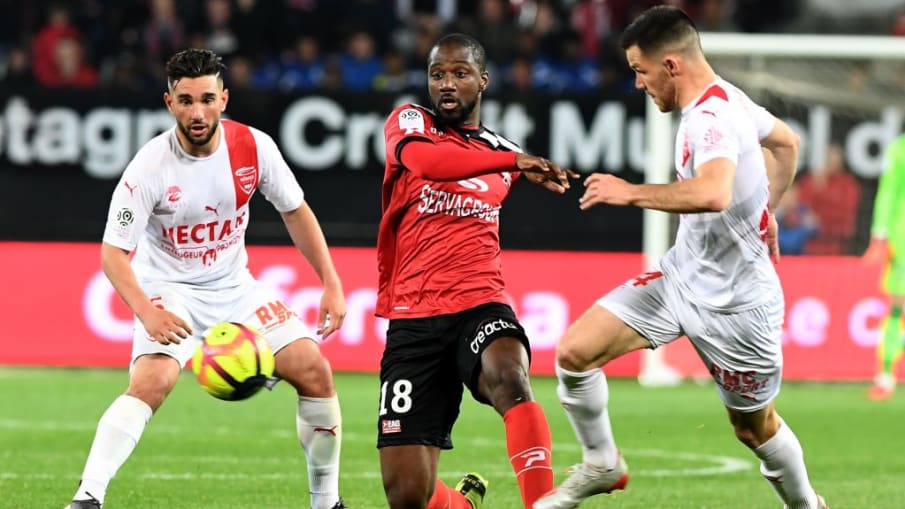 Guingamp's Lebogang Phiri kämpt gegen Nîmes Jordan Ferri und Antonin Bobichon um den Ball © 2019 Fred Tanneua/AFP/Getty Images Guingamp's Lebogang Phiri kämpt gegen Nîmes Jordan Ferri und Antonin Bobichon um den Ball © 2019 Fred Tanneua/AFP/Getty Images