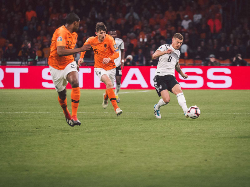 Toni Kroos überspielt niederländische Gegenspieler © 2019 Philipp Reinhard Der deutsche Nationalspieler Toni Kroos überspielt zwei niederländische Gegenspieler.