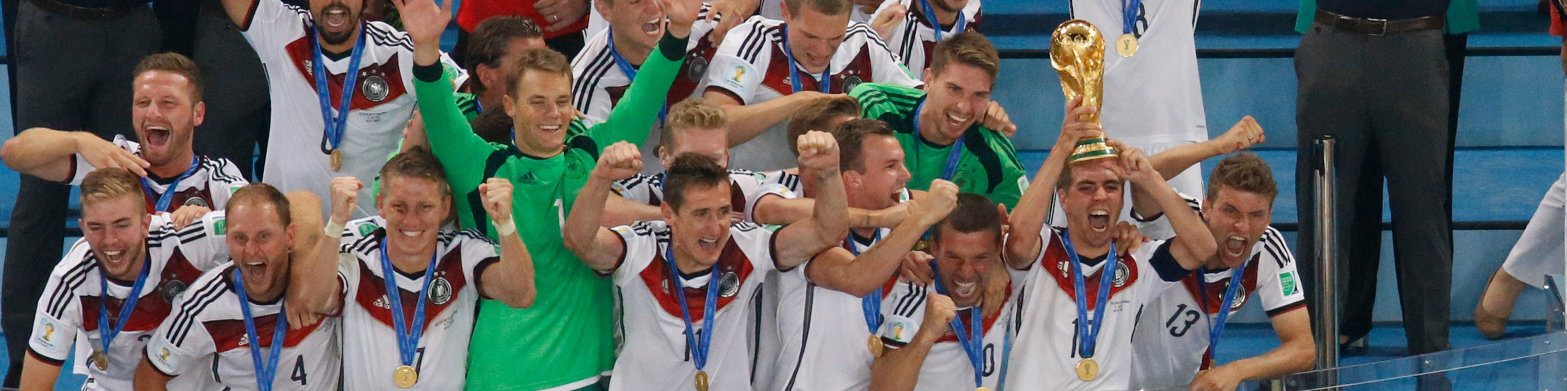FBL-WC-2014-MATCH64-GER-ARG Germany's defender and captain Philipp Lahm (front-R) holds up the World Cup trophy as he celebrates with his teammates after winning the final football match between Germany and Argentina for the FIFA World Cup at The Maracana Stadium in Rio de Janeiro on July 13, 2014. AFP PHOTO / FABRIZIO BENSCH/POOL (Photo credit should read FABRIZIO BENSCH/AFP via Getty Images)