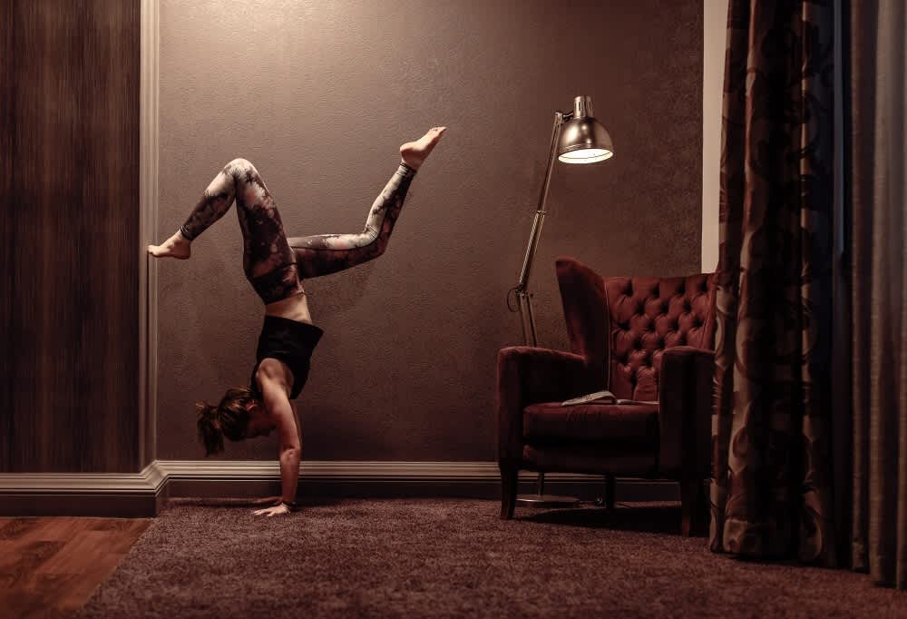 A woman doing yoga in her spacious Roomzzz serviced apartment.