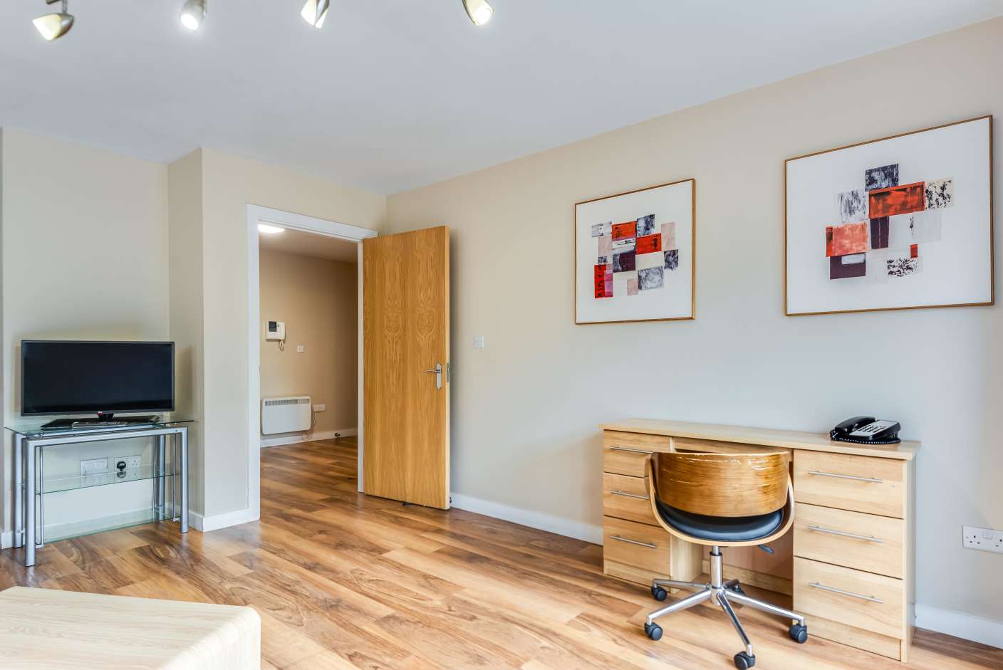 Dedicated workspace with wooden desk, drawers and office chair.