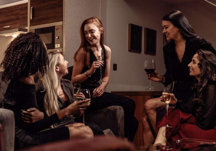 A group of women drinking together in their serviced apartment at Roomzzz.