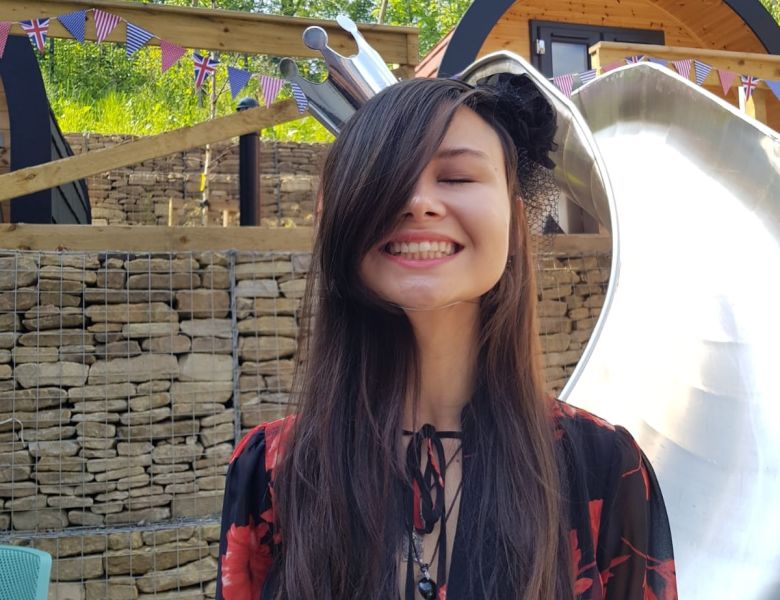 Smiling student next to slide at IconInc The Glassworks