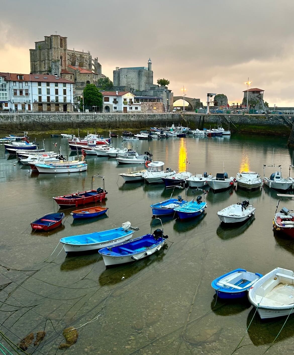 Puerto de Castro Urdiales con botes y la ciudad de fondo