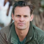 Close-up portrait of a man wearing a casual jacket outdoors.