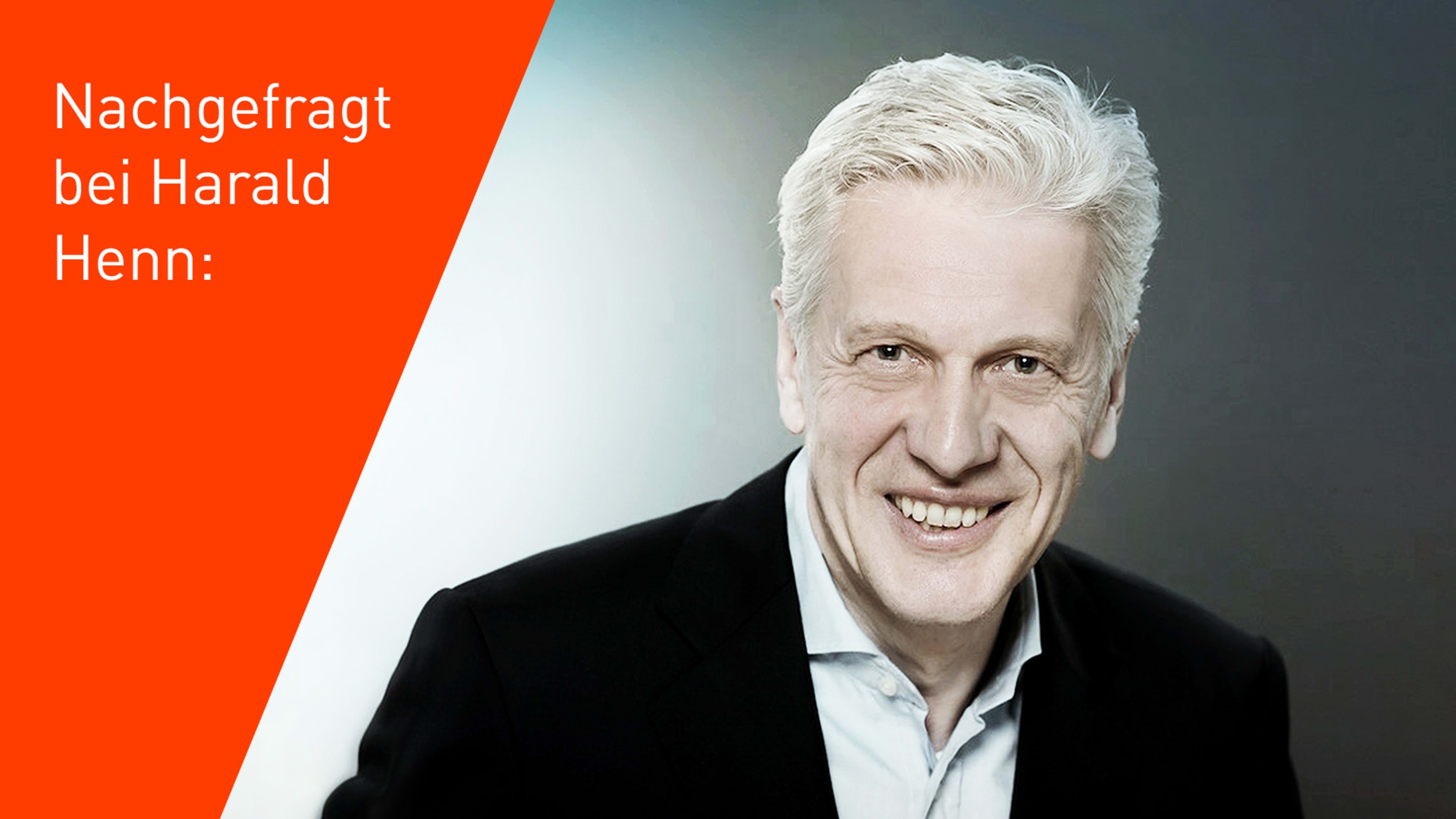 Lächelnder, älterer Mann mit grauem Haar vor einem orangem Hintergrund.