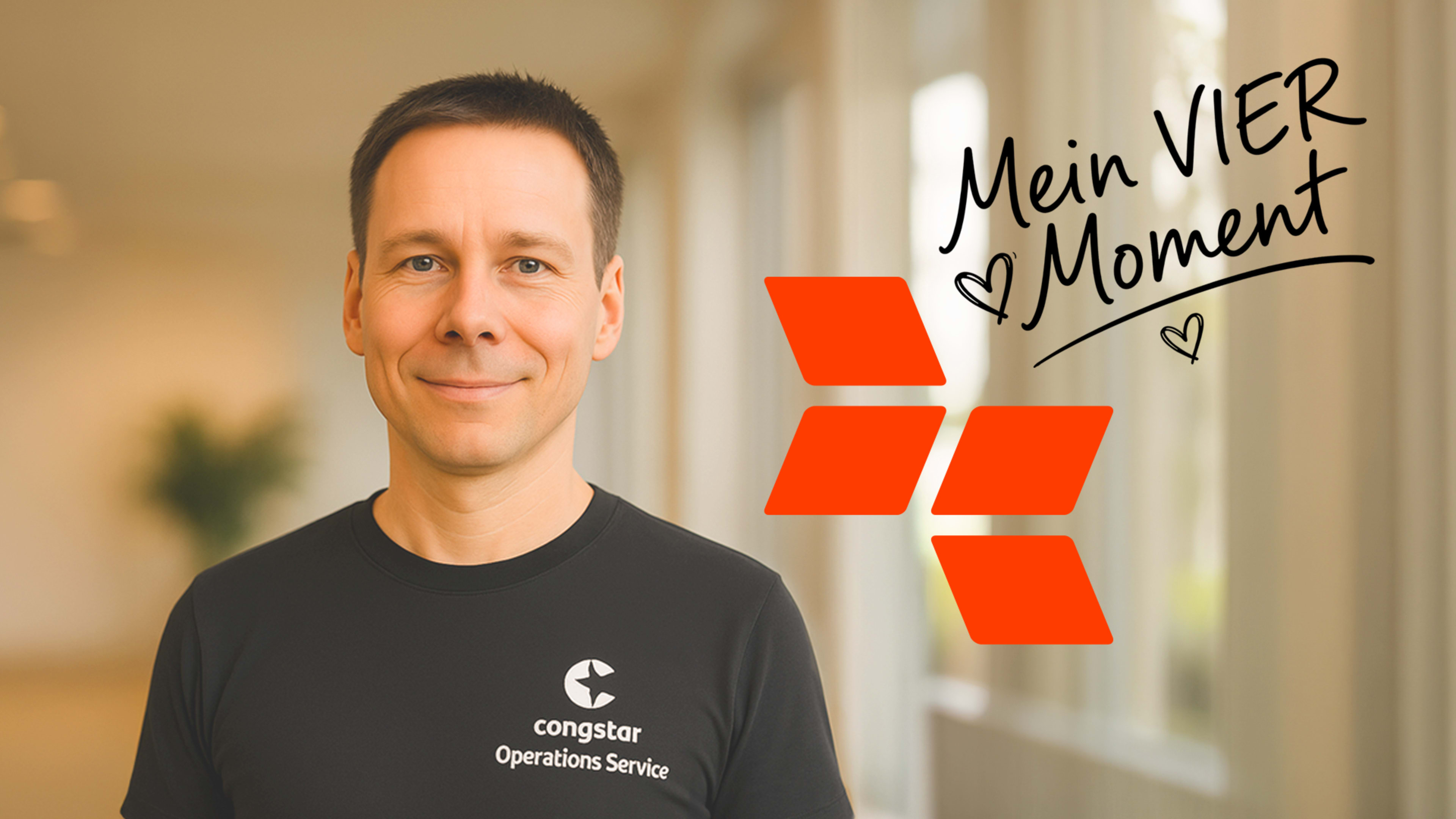 Ein Mann in einem schwarzen T-Shirt steht vor einem unscharfen Hintergrund mit einem Firmenlogo und handgeschriebenem Text.