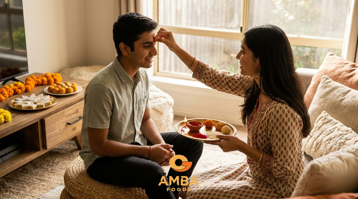 A sister applying a tilak to her brother's forehead beside a puja thali with a diya and Indian sweets