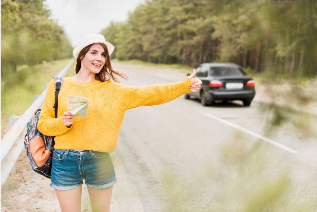 woman hitchhiking on the road.jpeg
