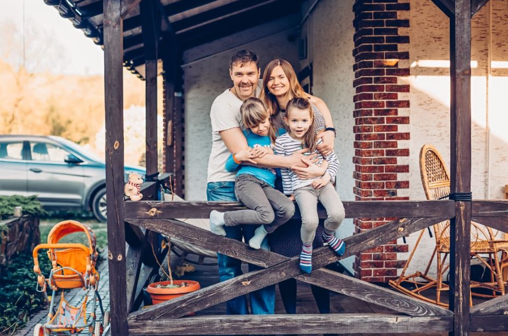 lächelnde-familie-vor-einem-haus.jpeg