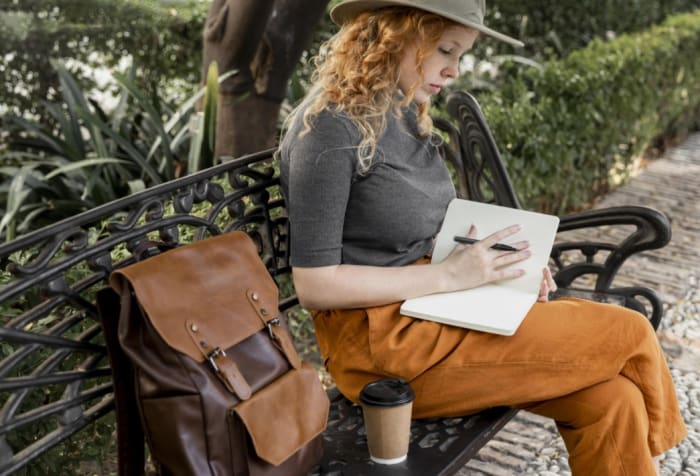 Une femme écrit dans un carnet de voyage