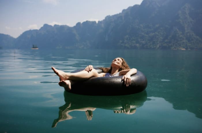 a woman chilling alone on a lake.png