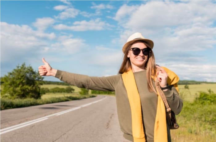 woman hitchhiking on the road.jpeg