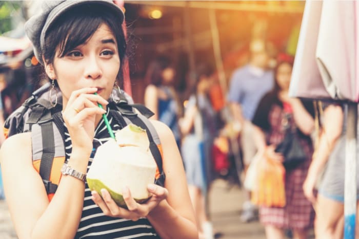 woman with backpack drinking from a coconut .jpeg