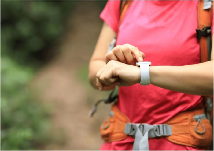 reiseaccessoires-person-mit-rucksack-traegt-eine-smartwatch-am-handgelenk.JPG