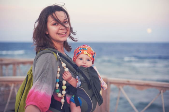 eine-Frau-die-ihr-Baby-am-Strand-trägt.JPG
