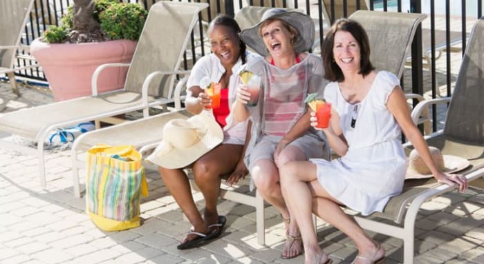 drei-frauen-sitzen-auf-liegestuehlen-und-halten-einen-drink-in-der-hand.jpeg