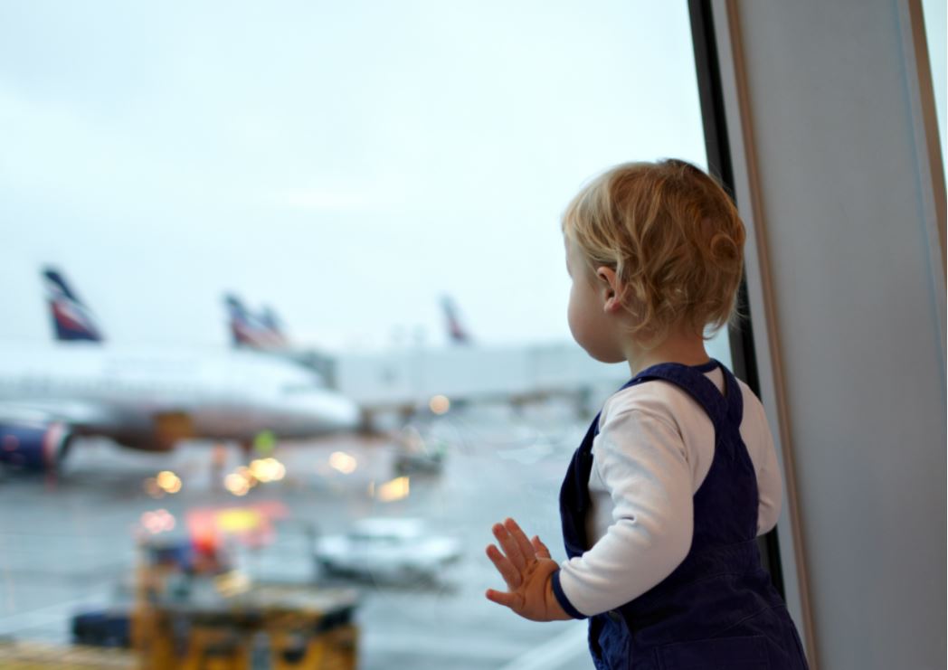 ein-Kind-das-ein-Flugzeug-auf-einem-Flughafen-beobachtet.JPG