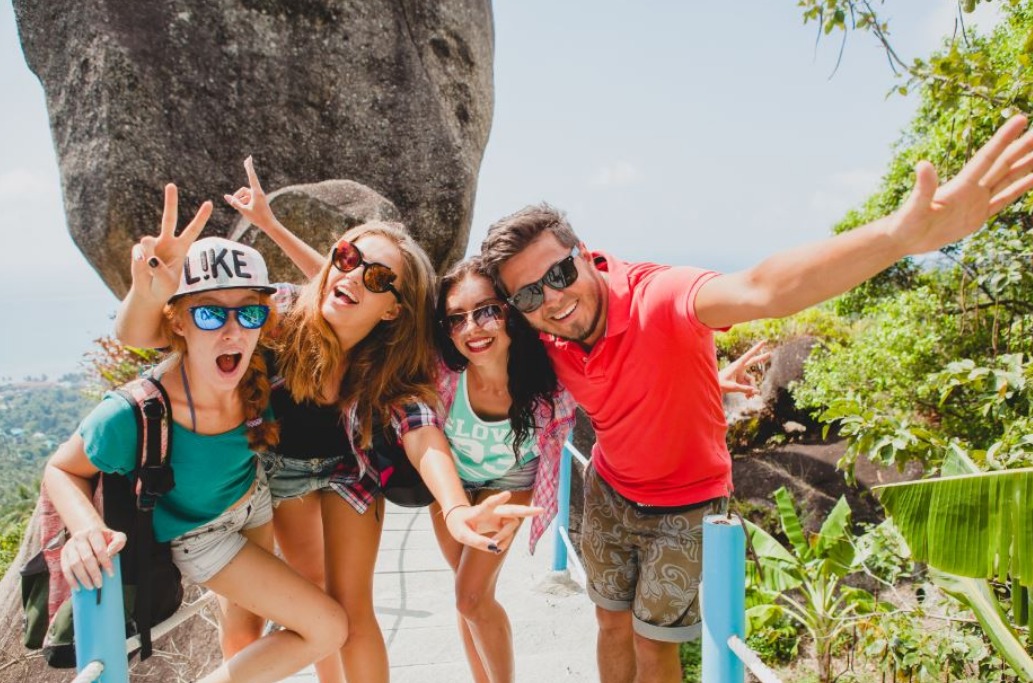 group-of-4-travellers-in-summer-clothes-smiling-in-nature.jpeg