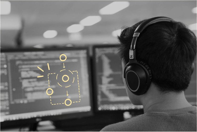 A black and white photo of a man wearing headphones looking at a computer screen